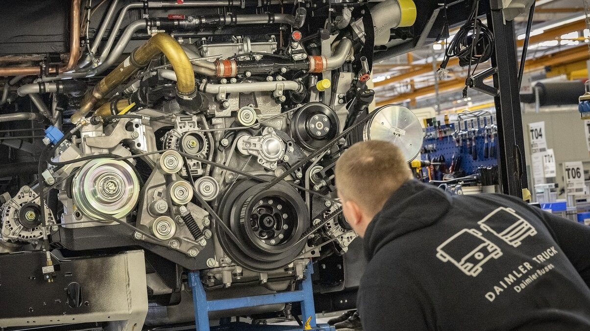 Employees of Daimler Buses during the installation of an engine in production.