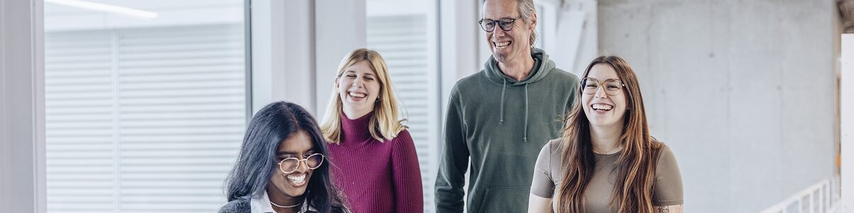 A group of four employees in a modern office building.