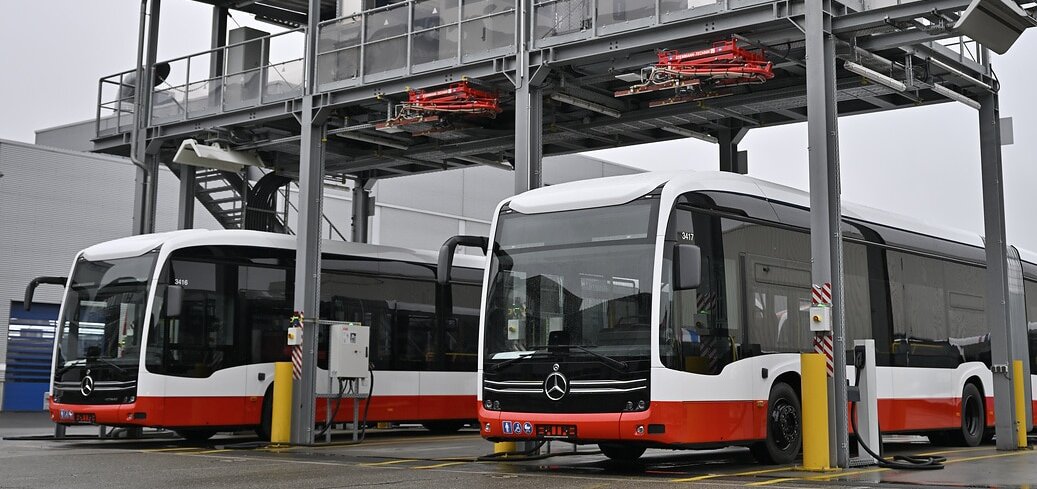 [Translate to Deutschland-en:] Electric buses from Mercedes-Benz are at a depot charging infrastructure with an automated charging system.