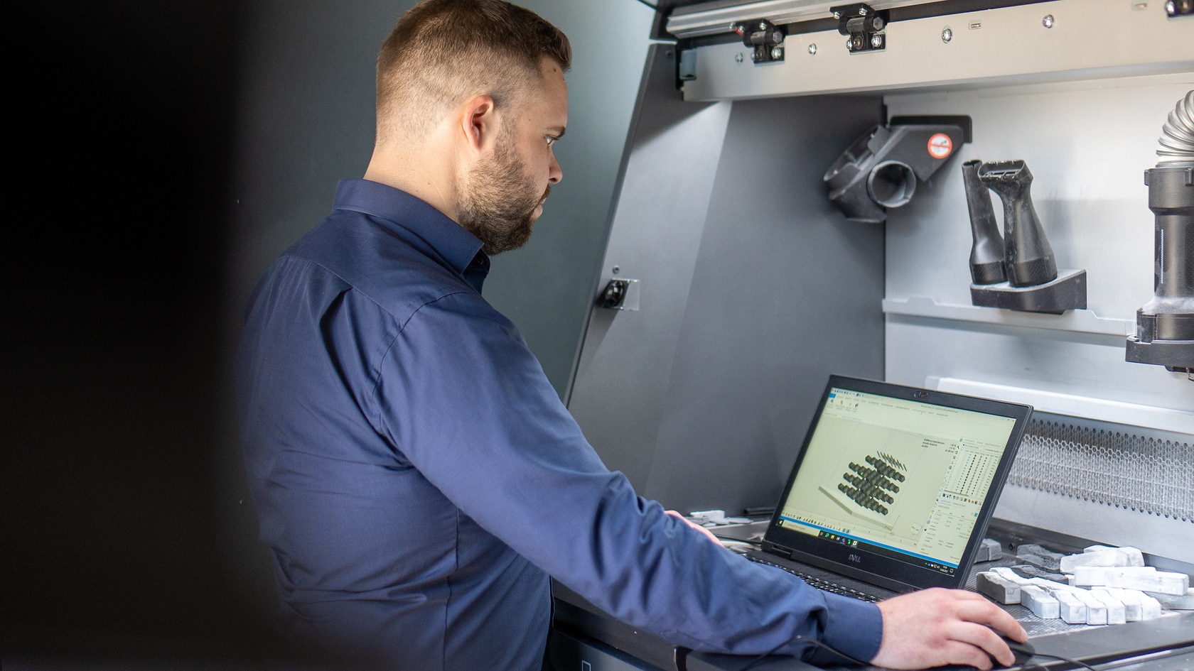 An employee is working on a digital 3D model on a laptop in a development environment at Daimler Buses.