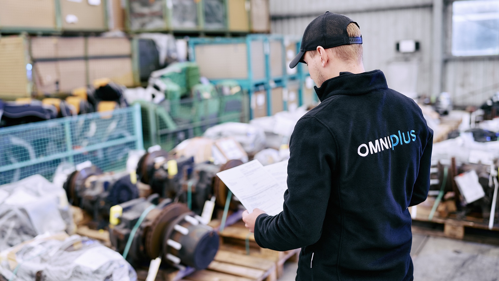 A person checks vehicle parts for reuse and spare parts management in a warehouse of the OMNIplus service brand.