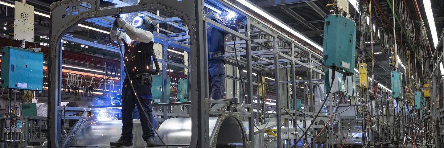 Employees produce bus bodies in a Daimler Buses production hall.